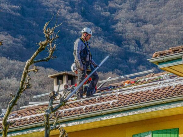 Un installateur rge panneaux solaires de Domosolaris sur un toit.