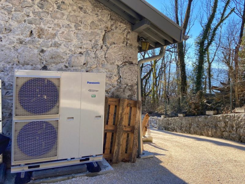 Un prix pompe a chaleur air eau installé par Domosolaris sur un mur en pierres.